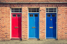 Three Differently Coloured Front Doors At The Entrance Of Old English Terraced Houses. Canterbury, England.