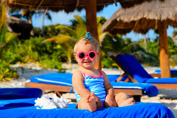 cute little girl play with seashells on beach