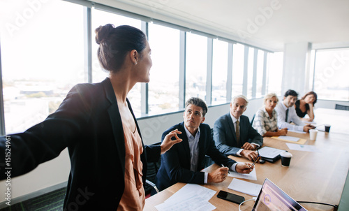 Cuadros en Lienzo Asian businesswoman giving presentation to coworkers