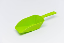 Green Plastic Measuring Spoon On The White Background
