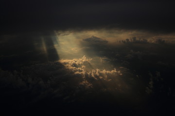 Rays of light shining through dark clouds on another cloud layer for background