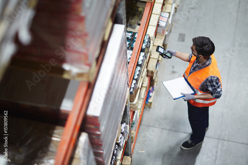 Fotografía Worker with scanner making review of goods in warehouse