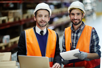 Wall Mural - Happy young workers of storage house looking at camera