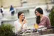 © BGStock72 - Two female friends sitting outside in a cafe and have fun