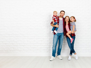 Wall Mural - Happy family mother, father, son, daughter on a white blank wall