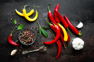 Canvas Print - Red hot chili pepeprs and peppercorns on black metal background, top view