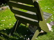 krzesło w ogrodzie i kot ukryty w cieniu