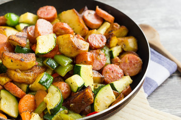 One pot sausage with colorful vegetables on cutting board