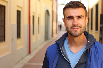 Wall Mural - Gorgeous man looking at camera outdoors