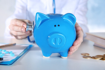 Poster - Doctor's hands with piggy bank, closeup