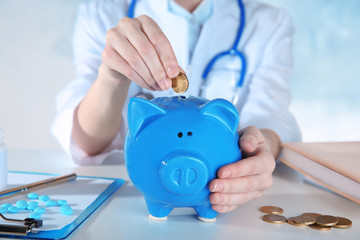 Poster - Doctor's hands with piggy bank, closeup