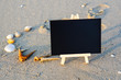 © NAWAWI - black board on sand beach .copy space area for concept