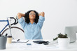 © wayhome.studio  - Beautiful young businesswoman with curly hair leaning back in chair, keeping hands behind her head and closing eyes while having a small break, doing paperwork at her workplace. People and business