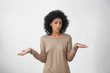 © wayhome.studio  - So what, Who cares. Unsure doubtful dark-skinned woman with black shaggy hair shrugging her shoulders in questioning gesture of uncertainty and keeping mouth opened, having confused clueless look