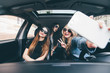 © F8  \ Suport Ukraine - Three beautiful young cheerful women making selfie and smiling while sitting in car together
