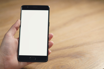 Wall Mural - closeup shot of female teen hands with smartphone at the table, shallow focus