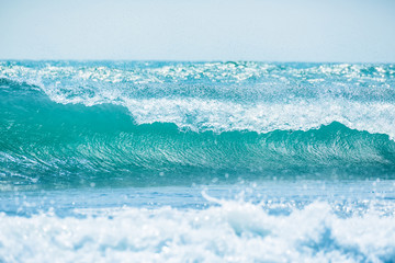 Blue wave in tropical ocean. Wave barrel crashing and sun light