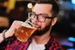 © Evgeniy Kalinovskiy - Bearded handsome man in a plaid shirt with a glass of beer