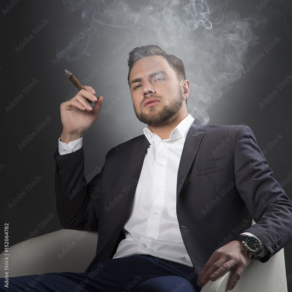 man in suit smoking cigarette Man in suit smoking cigar Stock Photo