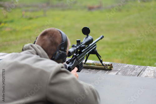 Fotomural A man sniper prepares to shoot at the target.