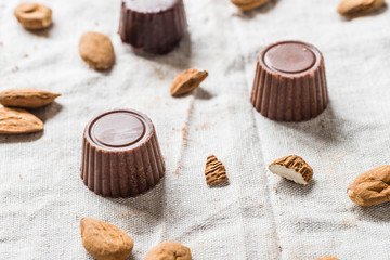 Wall Mural - Raw chocolate candies, homemade vegan sweets with almonds on cloth background