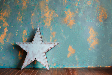 Green plaster wall and vintage metal star with lamps. Loft style