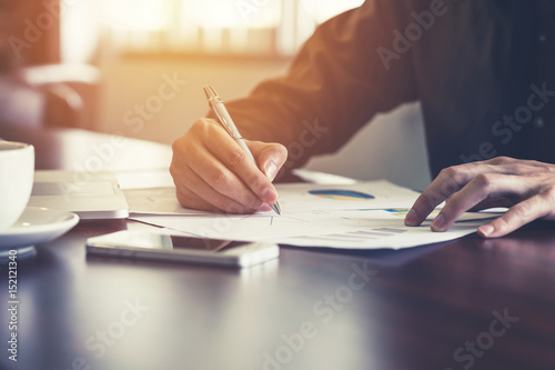 Fotomural Young business man hand writing paper in the office with sunlight