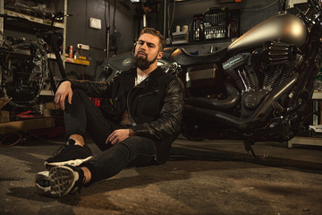 Wall Mural - Handsome bearded man on his motorbike at the workshop