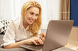 © Nestor - Gorgeous mature woman using a laptop resting at her house