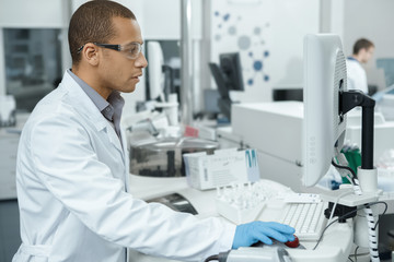 Professional scientist using computerized laboratory machine during the research
