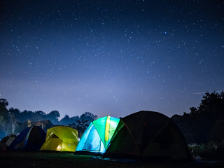night mountain landscape with illuminated tent