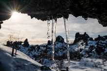 Frozen Dripping Water On The Stone Ceiling With Bright Sunlight In Winter