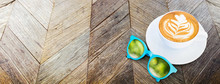 Hot Coffee Cup With Sunglasses And Reflection Of Green Tree Bokeh On Rustic Old Wood Plank Table Top View,Mock Up Banner For Adding Your Text Or Design