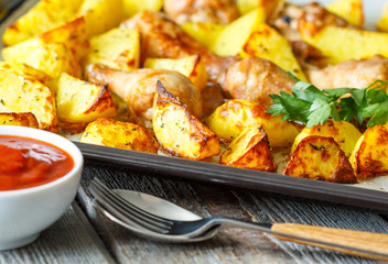 Wall Mural - Baked potatoes with chicken on a baking sheet.