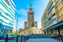 Palace Of Culture And Science In Warsaw On Sunny Day With Blue Sky And Green Trees. 