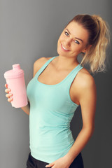 Poster - portrait of beautiful mature woman with bottle smiling in health club