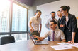 © WS Films - Happy creative business team using laptop in meeting at office