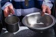 © kolotype - Prisoner's hands holding aluminum dishes in a hole for supplying food