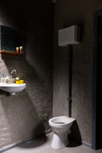 Toilet Near Washbasin With A Soap Box And Toothbrush On It Under The Mirror In A Prison Cell