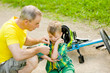 © Ermolaev Alexandr - Father puts a bandage on a wound to his son, who fell off his bicycle