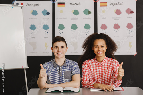 Smiling boy and girl with thumbs up Wallpaper Mural