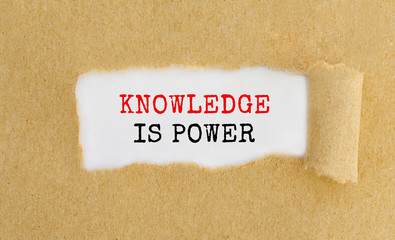 Poster - Text Knowledge is power appearing behind ripped brown paper