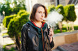 Modern young girl smoke electronic cigarette (vaping). Vaping concept