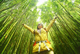 Fototapeta Dziecięca - Bamboo forest nature woman environment freedom with open arms in success. Environmental eco friendly sustainability concept. Hiker hiking on Pipiwai Trail on famous road to hana travel, Maui, Hawaii.