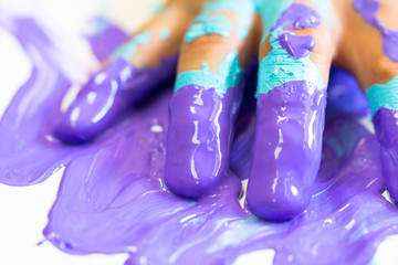 Hand and fingers messy and dirty by blue and purple paint as artist, decorator, house worker, creativity, painter concept background