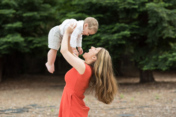 Cute Millennial mother holding todddler son