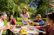 © Syda Productions - happy friends having dinner at summer garden party