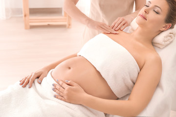 Wall Mural - young beautiful pregnant woman having massage in spa salon