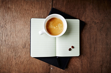 Wall Mural - Cup of Coffee on an open Notebook