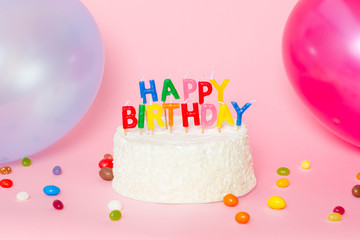 Happy Birthday cake on pink background with  balloons